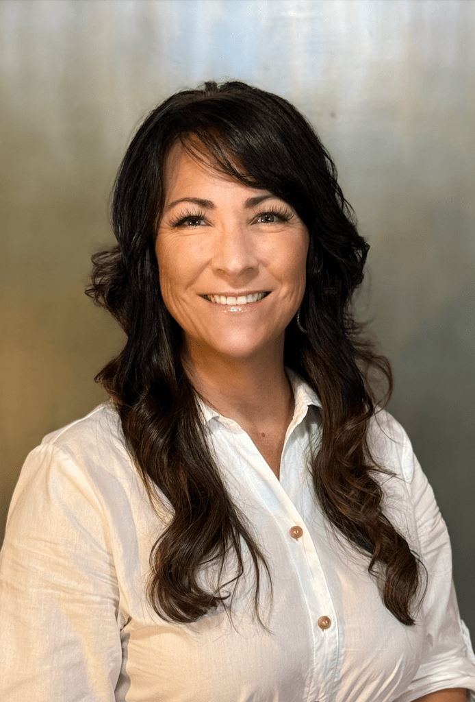 Windy Houser, founder of Gems of Knowledge, smiling in a white blouse